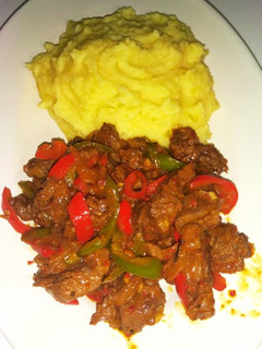A picture of Mashed potatoes and beef stir fry.