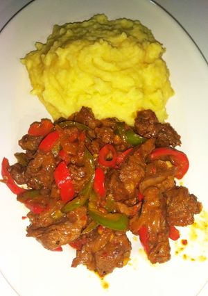 A picture of Mashed potatoes and beef stir fry.