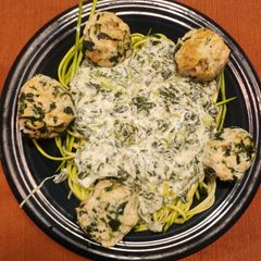 A picture of Chicken Florentine Meatballs over Zucchini Noodles.
