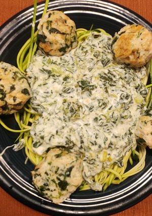 A picture of Chicken Florentine Meatballs over Zucchini Noodles.
