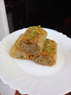 Una foto de Rollitos de baklava con nueces y pistachos