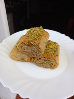 Una foto de Rollitos de baklava con nueces y pistachos