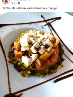 Una foto de Timbal de mango, queso fresco, guacamole y salmón marinado