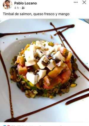 Una foto de Timbal de mango, queso fresco, guacamole y salmón marinado