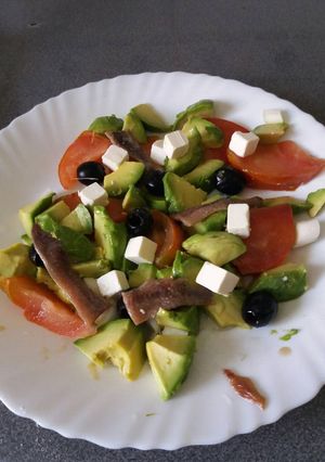 Una foto de Ensalada con tomate y aguacate y dados de queso