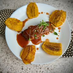A picture of Guava Kissed BBQ Salmon with Crispy Tostones 🏝️✨.