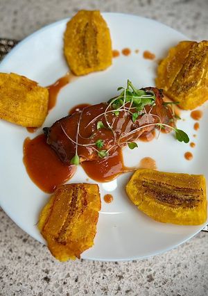 A picture of Guava Kissed BBQ Salmon with Crispy Tostones 🏝️✨.