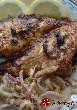 A picture of Redfish in the oven with an oil and oregano dressing.