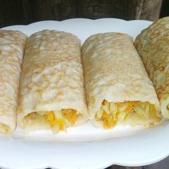 A picture of Crepes with veggies fillings.