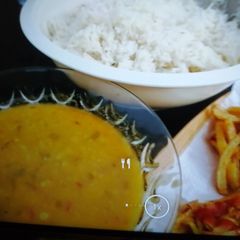 A picture of Boiled rice with daal and fries.