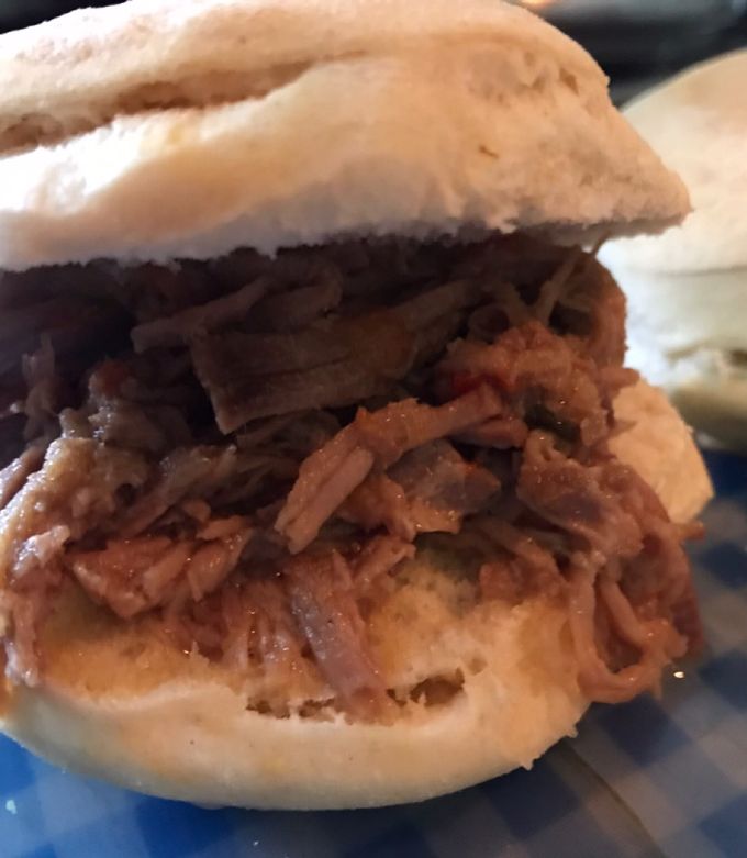 Una foto de Sándwich de carne desmechada con salsa de vino tinto, salteados y cebolla de verdeo