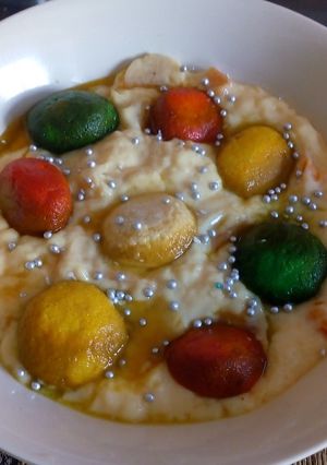 A picture of Colourful rasgulla in custard.