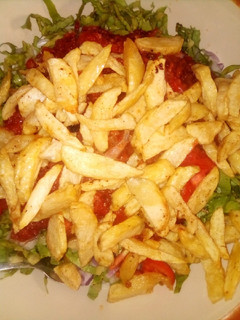 A picture of Chips with salad and sauce.