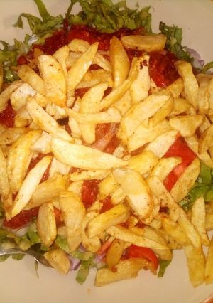 A picture of Chips with salad and sauce.