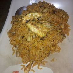 A picture of Jollof rice and beans with smoked fish.