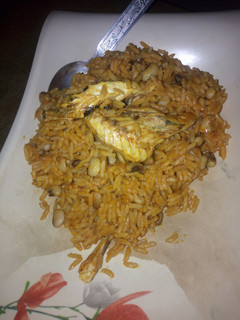 A picture of Jollof rice and beans with smoked fish.