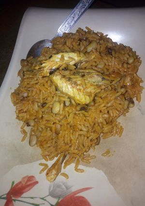 A picture of Jollof rice and beans with smoked fish.
