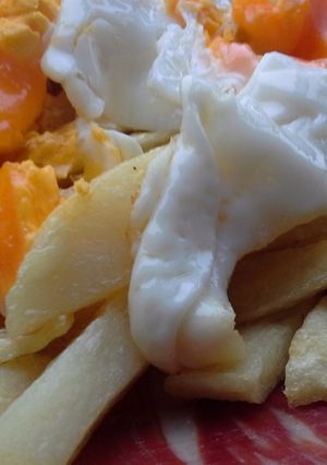 Una foto de Huevos rotos con jamón de bellota y aceite de trufa
