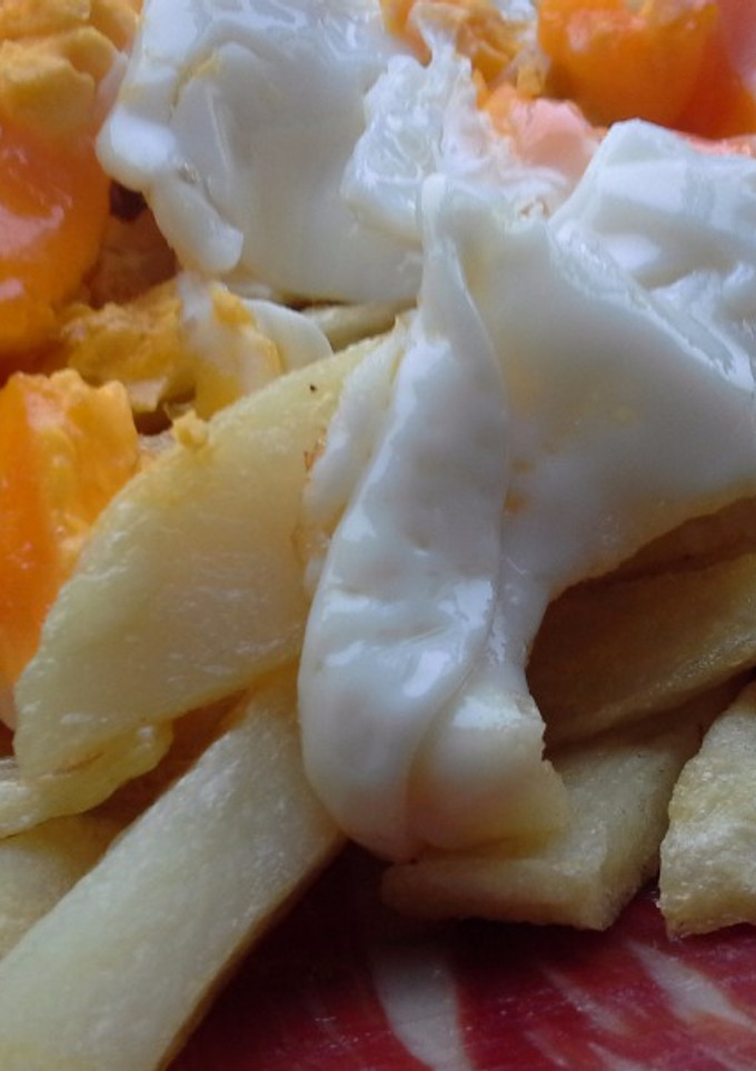 Una foto de Huevos rotos con jamón de bellota y aceite de trufa