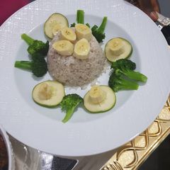 A picture of Ofada rice excited by broccoli, banana and cucumber.