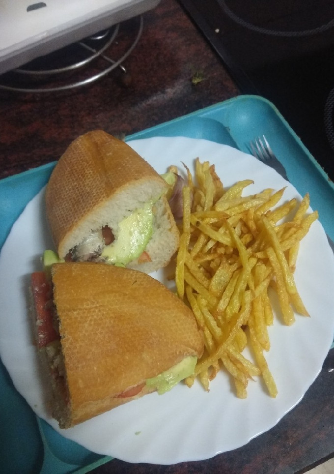 Una foto de Bocadillo de sardinas con aguacate, tomate y papas fritas