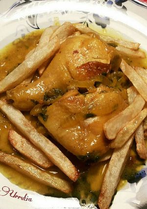 Foto principal de Pollo en salsa de cebolla y perejil especiado con patatas fritas