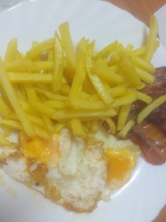 Una foto de Huevos fritos con papas fritas y crujiente de embutidos
