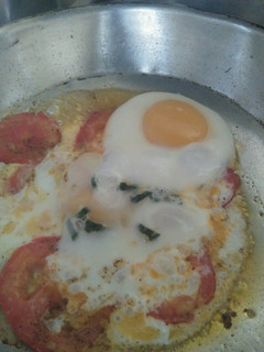 A picture of Sunny side up Eggs with tomato.