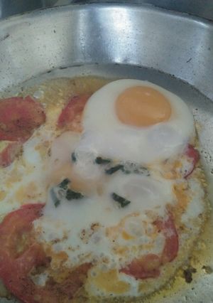 A picture of Sunny side up Eggs with tomato.