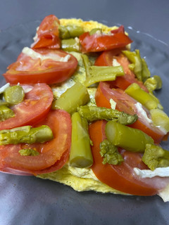 Una foto de Tortilla de calabacín con tomate, queso de Cabra y espárragos verdes al lekue