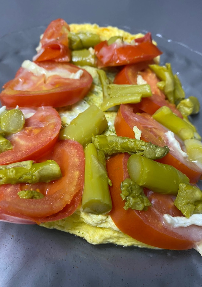 Una foto de Tortilla de calabacín con tomate, queso de Cabra y espárragos verdes al lekue