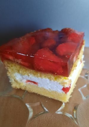 Zdjęcie przepisu Biszkopt z galaretką, bitą śmietaną i truskawkami.