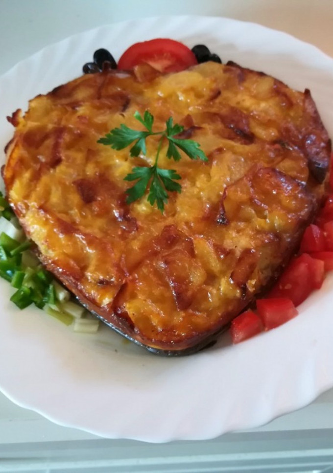 Una foto de Tortilla de patatas, queso y jamón al horno