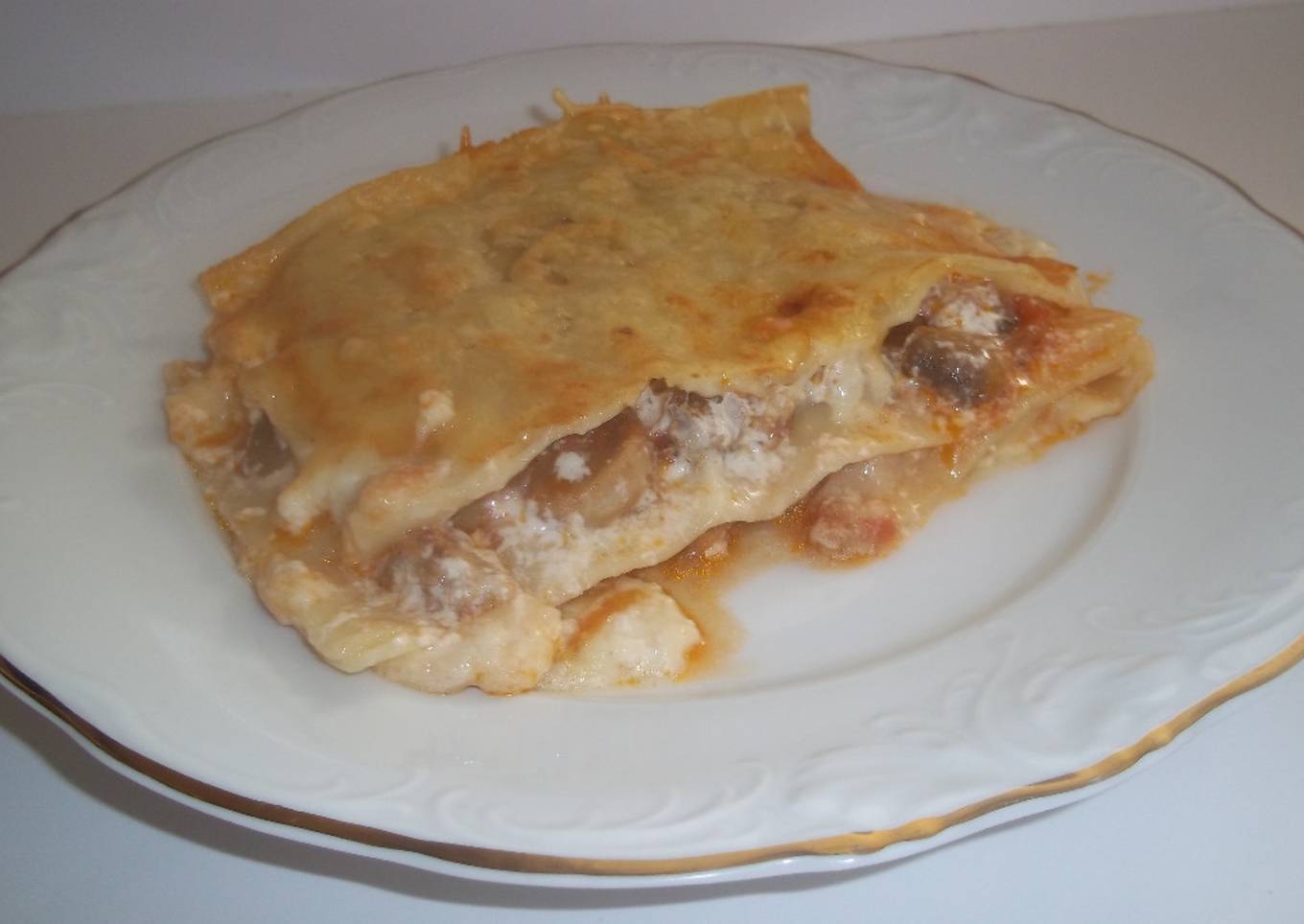 Lasaña de carne picada de cerdo, lonchas de queso  y gratinada