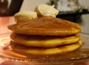 Una foto de Pancakes de naranja🍊 y miel 🍯 esponjosísimos con syrup de caramelo miel y cogñac 🍾