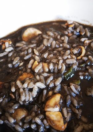 Una foto de Arroz negro caldoso con calamares y verduras en Mambo