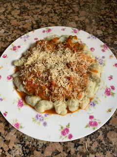 Una foto de Ñoquis de papa con salsa y pollo
