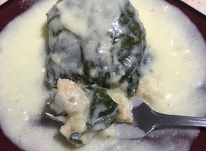 Una foto de Tamales canarios en hoja de acelgas, con crema de piña