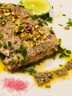 Una foto de Corvina en hummus de aceitunas negras y pistacho
