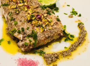 Una foto de Corvina en hummus de aceitunas negras y pistacho