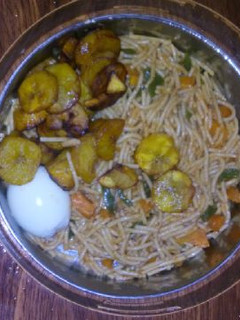 A picture of Spagetti with fried plantain,egg and vegetable.
