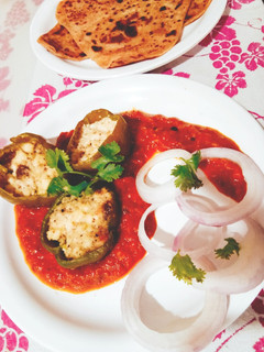 A picture of Punjabi Paneer stuffed Capsicum in Red Gravy.