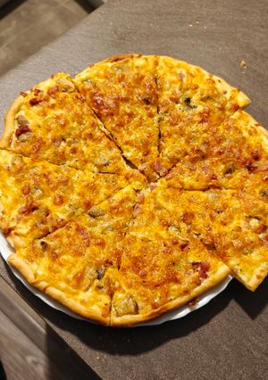 Una foto de Pizza estilo carbonara sin nata ni cebolla