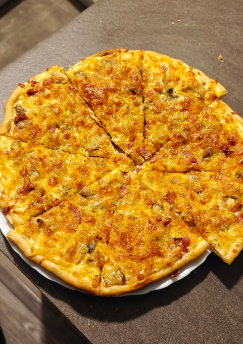 Una foto de Pizza estilo carbonara sin nata ni cebolla