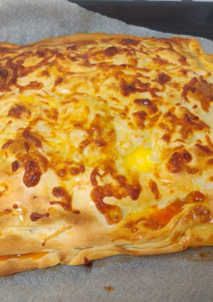 Una foto de Pizza calzone de pollo, tomate, pimientos, cebolla y queso