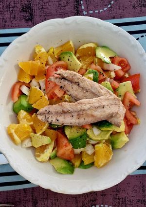 Una foto de Ensalada de tomates, aguacate y naranjas con melva