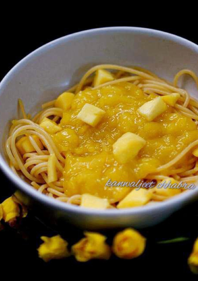 A picture of Spaghetti in mango sauce topped with mango cubes.