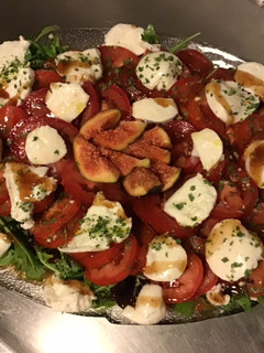 Une photo de Salade de tomates,roquette,mozzarella di buffala et figues du jardin sauce au vinaigre de figues