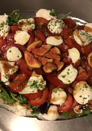 Une photo de Salade de tomates,roquette,mozzarella di buffala et figues du jardin sauce au vinaigre de figues