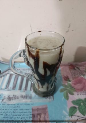 A picture of Banana shake with choclate syrup.